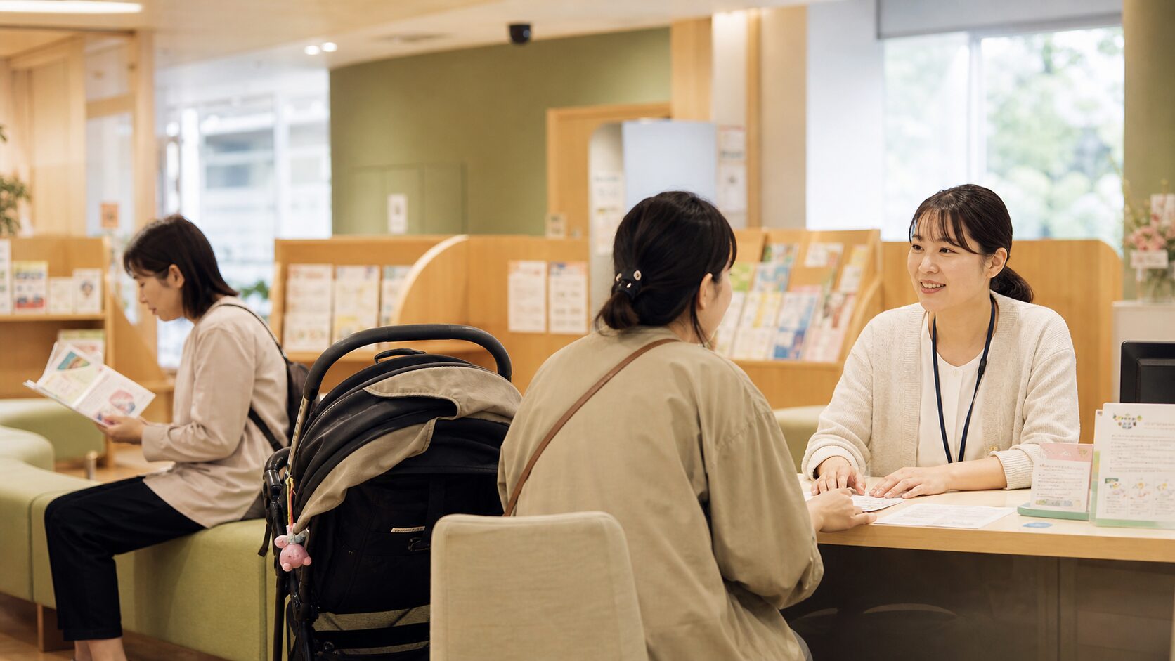 日進市の窓口で申請の相談をする母親